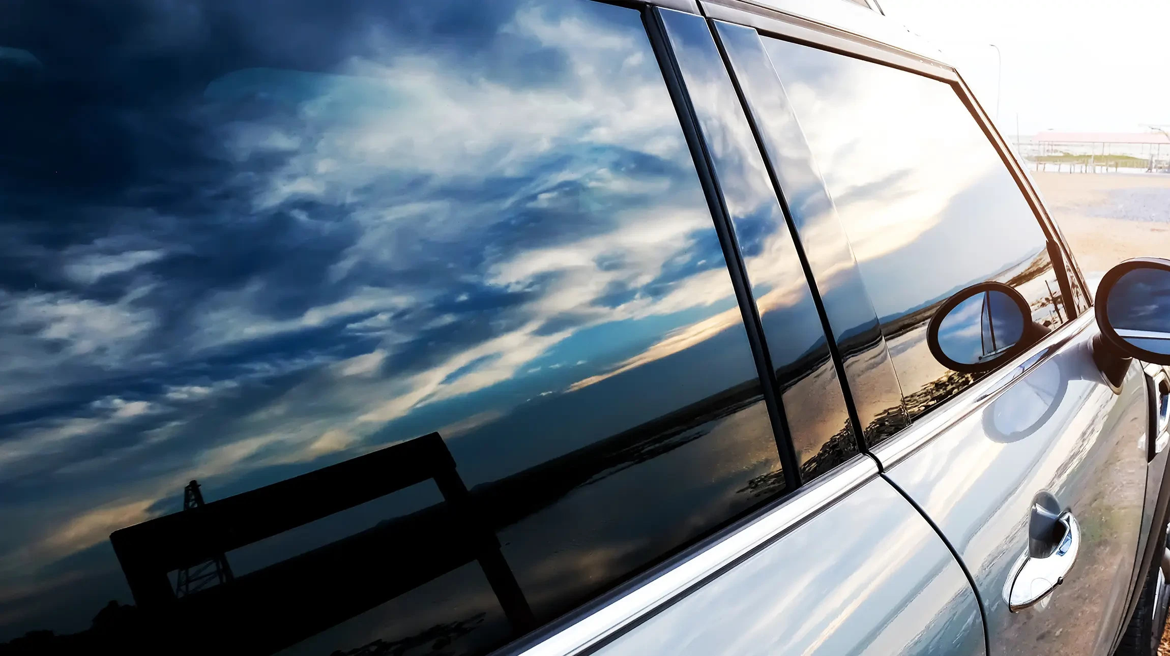 Femme conductrice portant lunettes de soleil au volant d'un cabriolet de luxe, intérieur cuir beige, paysage verdoyant en arrière-plan