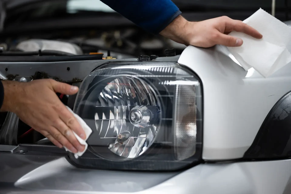 Scène intérieure industrielle avec moto d'aventure recouverte d'une mousse blanche de lavage haute pression